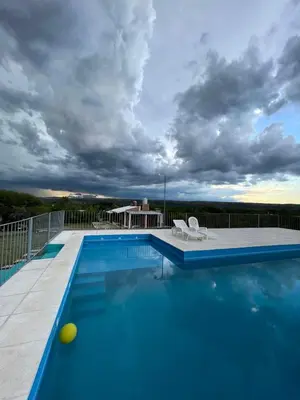 a swimming pool on a balcony with a cloudy sky at Lucero de Brochero in Villa Cura Brochero