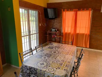 a dining room with a table with chairs and a television at Lucero de Brochero in Villa Cura Brochero