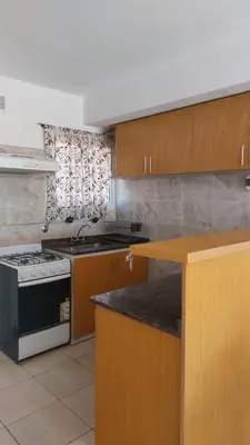 a kitchen with wooden cabinets and a stove top oven at Duplex al pie de las sierras in Villa Carlos Paz