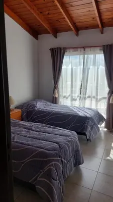 two beds sitting in a room with a window at Duplex al pie de las sierras in Villa Carlos Paz