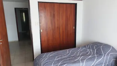a bedroom with a bed and a wooden door at Duplex al pie de las sierras in Villa Carlos Paz