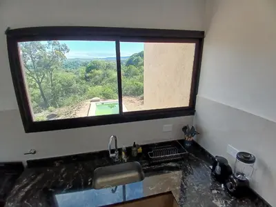 a kitchen with a window above a sink with a view at Balcon del rio in Cavalango