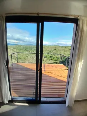 a door to a deck with a view of the desert at Balcon del rio in Cavalango