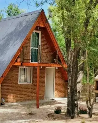 a small brick house with a tree in front of it at Alpinanas in Arroyo de Los Patos