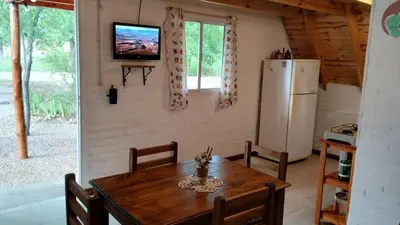 a kitchen with a wooden table and a refrigerator at Alpinanas in Arroyo de Los Patos