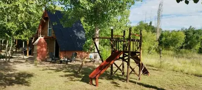 a playground in front of a house with a building at Alpinanas in Arroyo de Los Patos