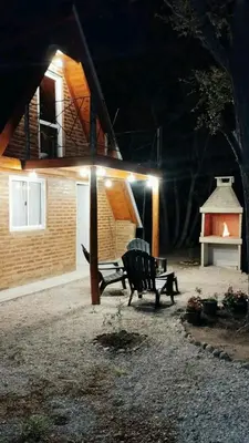 a park bench in front of a house at night at Alpinanas in Arroyo de Los Patos