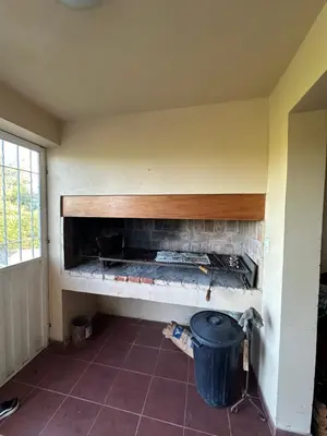 a brick fireplace in a room with a trash can at Casa Siquiman in Villa Parque Siquiman