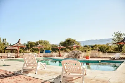 two white chairs sitting next to a swimming pool at Cabañas Achikilla in Las Calles