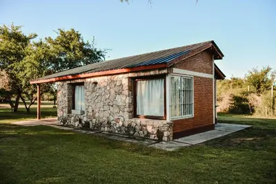 a small brick building with a window on a grass field at Cabañas Achikilla in Las Calles