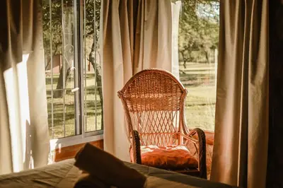 a wicker chair sitting in front of a window at Cabañas Achikilla in Las Calles
