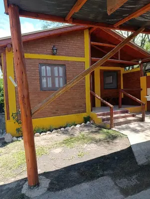 a yellow house with a pole in front of it at Cabaña villa ediht in Villa Parque Siquiman