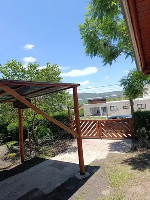 a wooden gate to a house with a roof at Cabaña villa ediht in Villa Parque Siquiman