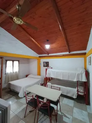a room with two beds and a table and chairs at Cabaña villa ediht in Villa Parque Siquiman