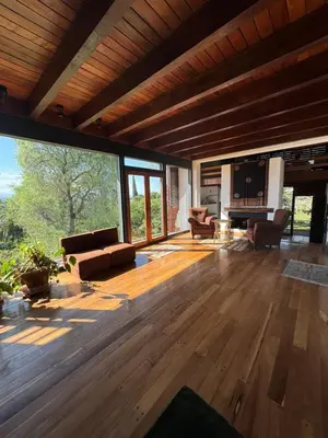 a living room with wooden floors and a large window at Casa de diseño en Costa Azul in Villa Carlos Paz