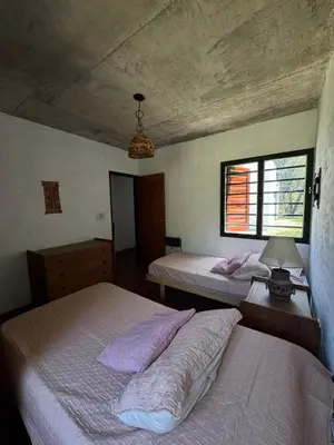 two beds in a bedroom with two windows at Casa de diseño en Costa Azul in Villa Carlos Paz