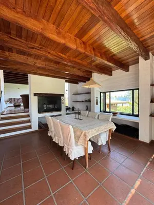 a large dining room with a table and a fireplace at Casa de diseño en Costa Azul in Villa Carlos Paz