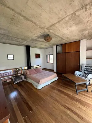 a large bedroom with a bed and a wooden floor at Casa de diseño en Costa Azul in Villa Carlos Paz