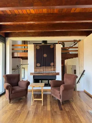a living room with two chairs and a fireplace at Casa de diseño en Costa Azul in Villa Carlos Paz