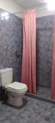 a bathroom with a toilet and a pink shower curtain at Bella Fefi in Villa Cura Brochero