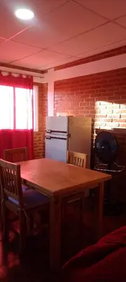 a kitchen with a wooden table and a refrigerator at Bella Fefi in Villa Cura Brochero