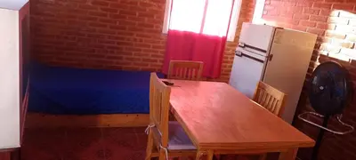 a kitchen with a wooden table and a refrigerator at Bella Fefi in Villa Cura Brochero