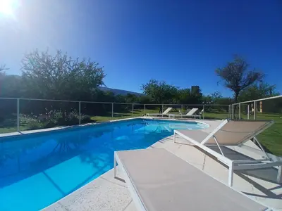 a swimming pool with two lounge chairs next to it at Complejo El Caldén in Merlo