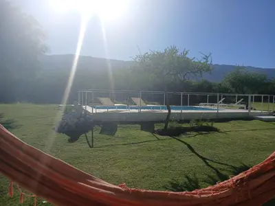 a hammock in a field of grass with a bridge at Complejo El Caldén in Merlo