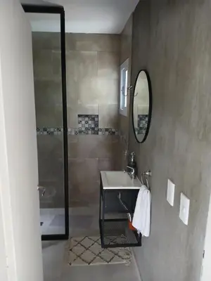 a bathroom with a sink and a mirror and a shower at Complejo El Caldén in Merlo