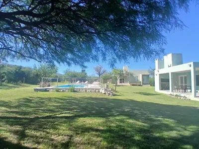 a large yard with a pool and a house at Complejo El Caldén in Merlo