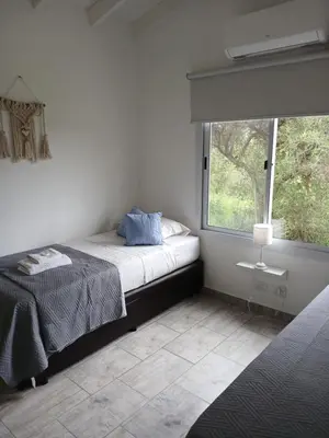 a bedroom with a bed and a large window at Complejo El Caldén in Merlo