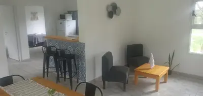 a living room with tables and chairs and a counter at Complejo El Caldén in Merlo