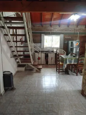 a living room with a table and a kitchen at Solares LOFT in Mina Clavero