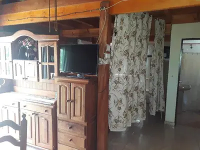 a living room with a television on a wooden cabinet at Solares LOFT in Mina Clavero