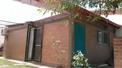 a red brick house with a green door at Solares LOFT in Mina Clavero