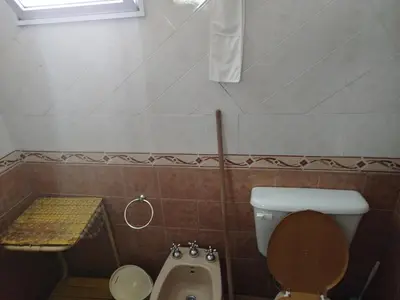a bathroom with a toilet and a urinal and a sink at Solares LOFT in Mina Clavero