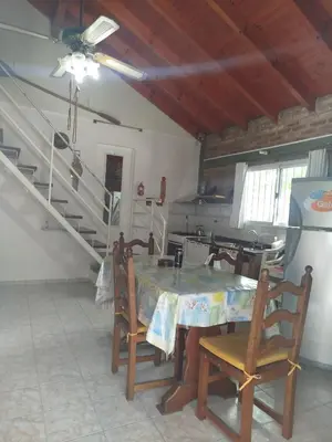 a dining room with a table and chairs and stairs at Solares LOFT in Mina Clavero