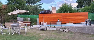a group of chairs and an umbrella next to a pool at Apartamento Jhaky 2 in Villa Carlos Paz