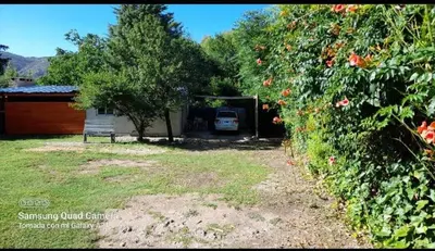a yard with a bench and a car in a garage at Apartamento Jhaky 2 in Villa Carlos Paz