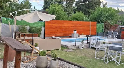 a backyard with a swimming pool and an umbrella at Apartamento Jhaky 2 in Villa Carlos Paz