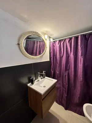 a bathroom with a sink and a purple shower curtain at Moderno dpto zona norte 1 dorm in Cordoba