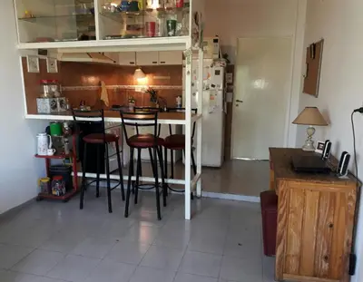 a kitchen with a bar with stools and a refrigerator at Arturo in Cordoba