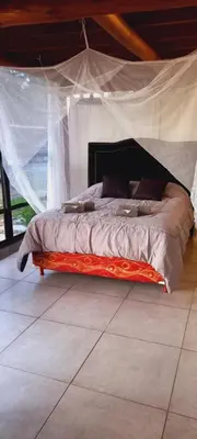 a bed with a canopy in a room at Lo de Nor - Refugio de Montaña in San Antonio de Arredondo