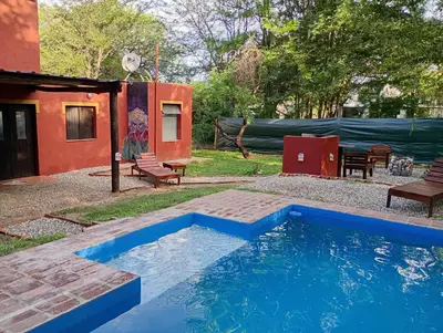 a swimming pool in a yard with a house at Casa con piscina privada en las sierras de Córdoba in Villa Anizacate