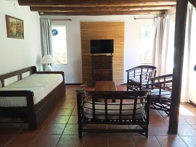 a bedroom with a bed and a tv and two chairs at Casa con piscina privada en las sierras de Córdoba in Villa Anizacate