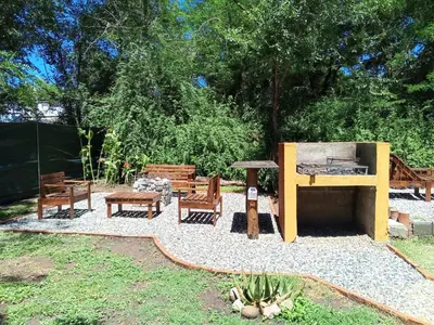 a backyard with benches and a grill and a table at Casa con piscina privada en las sierras de Córdoba in Villa Anizacate