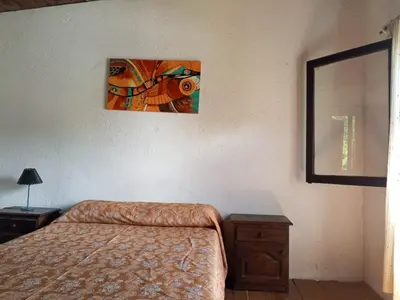 a bedroom with a bed and a picture on the wall at Casa con piscina privada en las sierras de Córdoba in Villa Anizacate