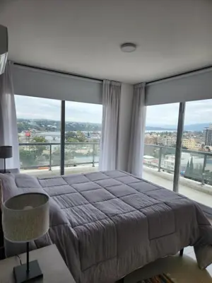 a bedroom with a large bed and large windows at Civis Tower Excepcional Departamento in Villa Carlos Paz