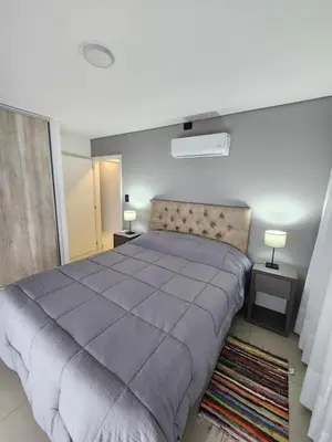 a bedroom with a large bed and two lamps at Civis Tower Excepcional Departamento in Villa Carlos Paz
