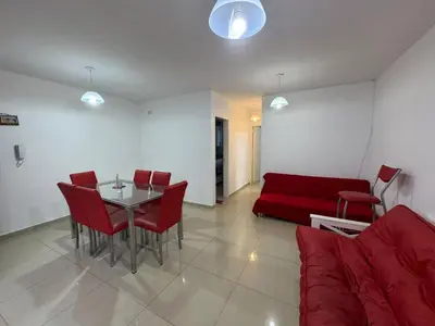 a living room with a red couch and a table at Myng Departamento en el centro de Carlos Paz in Villa Carlos Paz